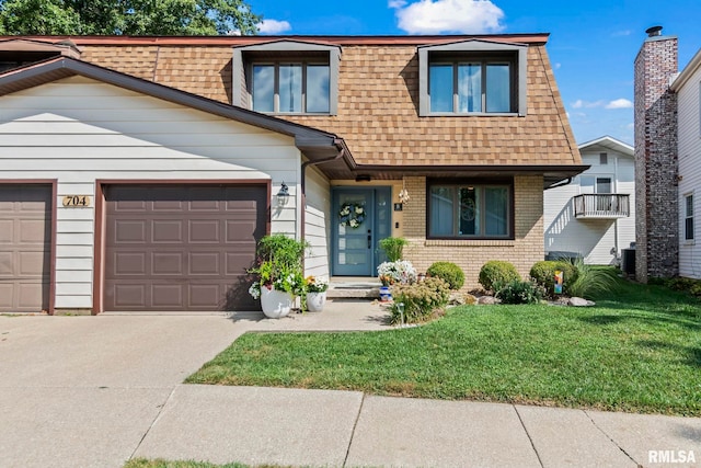 704 Rickard Rd, Springfield, IL 62704 - multi unit property featuring roof with shingles, an attached garage, concrete driveway, a front lawn, and mansard roof
