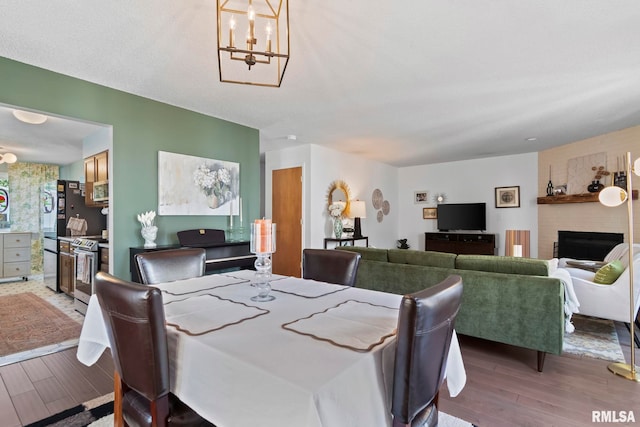704 Rickard Rd, Springfield, IL 62704 - dining area with wood finished floors, a chandelier, and a fireplace