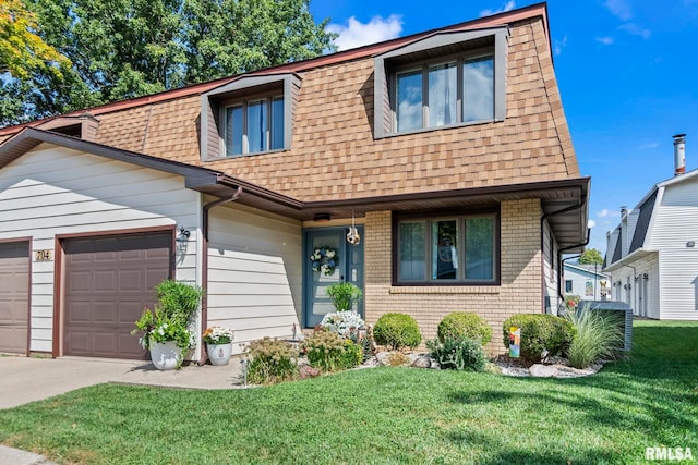 704 Rickard Rd, Springfield, IL 62704 - townhome / multi-family property featuring a shingled roof, concrete driveway, a front lawn, and a garage
