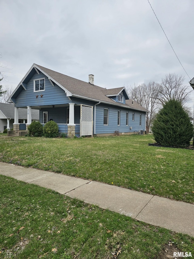 216 W Church St, Palmyra, MO 63461 - view of front facade featuring a porch, a front yard, a shingled roof, and a chimney