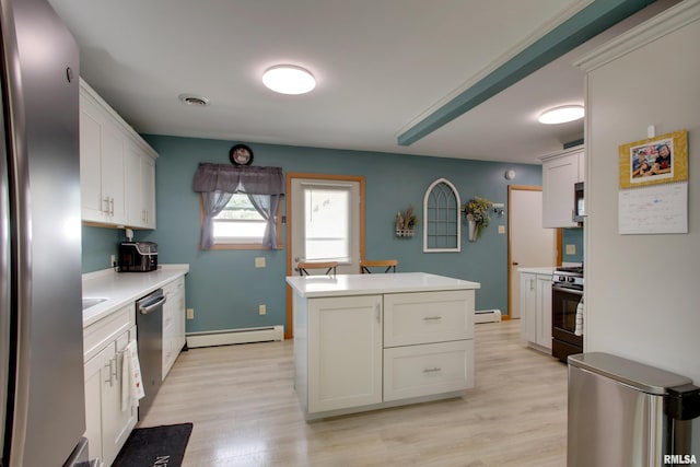 130 S State St, Mendon, IL 62351 - kitchen with appliances with stainless steel finishes, a baseboard radiator, a kitchen island, and light wood-style flooring