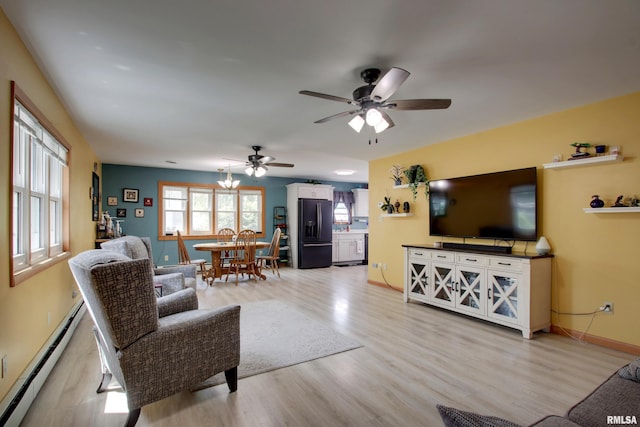 130 S State St, Mendon, IL 62351 - living area with a baseboard heating unit, light wood finished floors, a ceiling fan, and baseboards