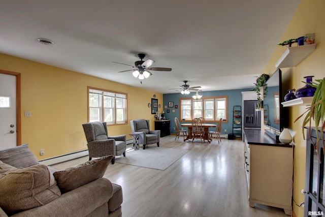 130 S State St, Mendon, IL 62351 - living room featuring a baseboard heating unit, a ceiling fan, light wood-type flooring, and a baseboard radiator