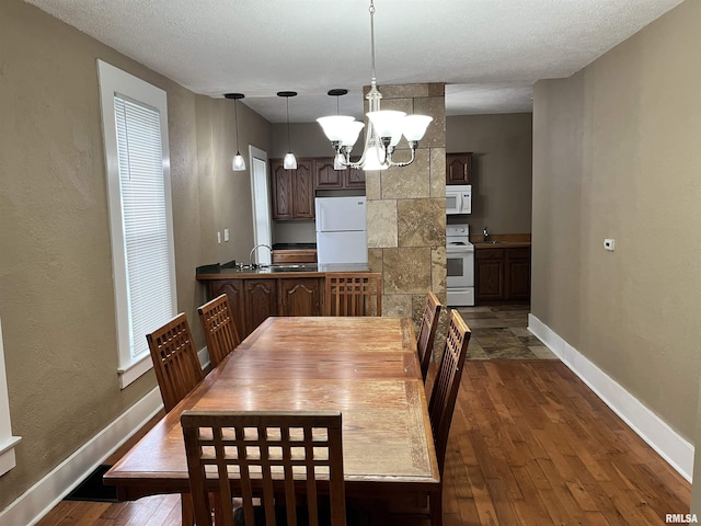 626 W Edwards St, Springfield, IL 62704 - dining area with dark wood-style floors, a chandelier, baseboards, and a textured ceiling