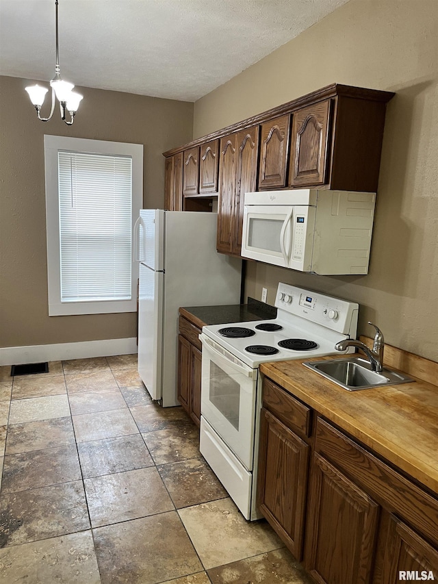 626 W Edwards St, Springfield, IL 62704 - kitchen featuring white appliances, a sink, a chandelier, pendant lighting, and dark brown cabinetry