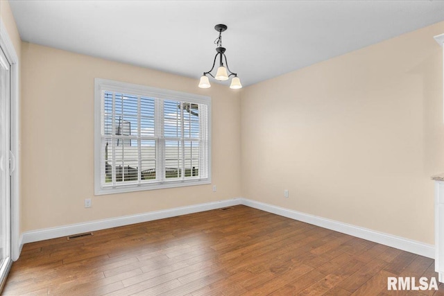 1809 Spartan Dr, Chatham, IL 62629 - empty room featuring hardwood / wood-style floors, baseboards, and a chandelier