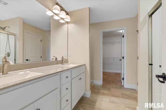 1809 Spartan Dr, Chatham, IL 62629 - full bathroom with double vanity, baseboards, a spacious closet, and an enclosed shower
