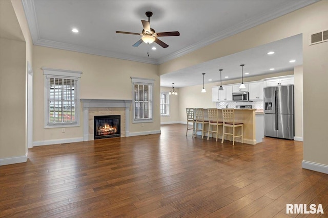 1809 Spartan Dr, Chatham, IL 62629 - living room with a ceiling fan, dark wood-style flooring, baseboards, a tiled fireplace, and ornamental molding
