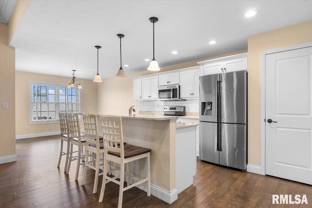 1809 Spartan Dr, Chatham, IL 62629 - kitchen with appliances with stainless steel finishes, dark wood-style flooring, baseboards, a center island with sink, and recessed lighting
