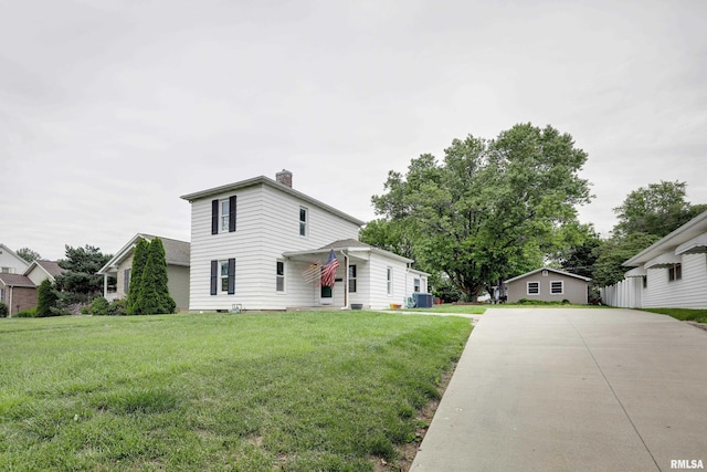 2911 Hampshire St, Quincy, IL 62301 - view of side of property with a chimney, a yard, central AC unit, and concrete driveway