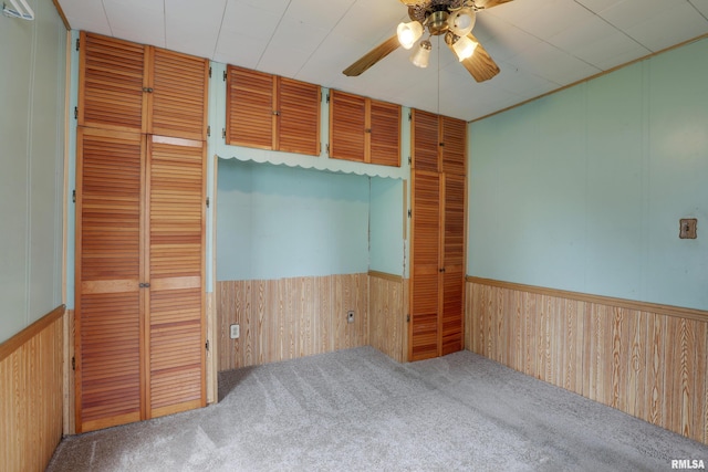 2911 Hampshire St, Quincy, IL 62301 - empty room with wood walls, a ceiling fan, carpet floors, and wainscoting