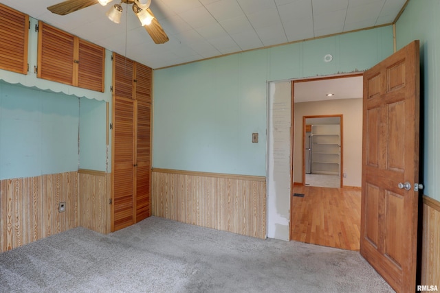 2911 Hampshire St, Quincy, IL 62301 - empty room featuring ceiling fan, wood walls, carpet floors, and a wainscoted wall