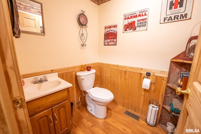 2061 N 425th St, Vandalia, IL 62471 - bathroom featuring a wainscoted wall, vanity, toilet, wood finished floors, and wooden walls