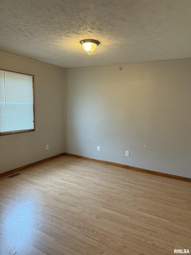515 Morgan St, Chapin, IL 62628 - unfurnished room with a textured ceiling, light wood-style flooring, and baseboards