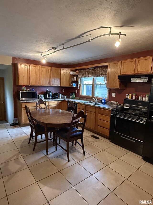515 Morgan St, Chapin, IL 62628 - kitchen featuring black range with gas stovetop, under cabinet range hood, stainless steel microwave, open shelves, and light tile patterned floors
