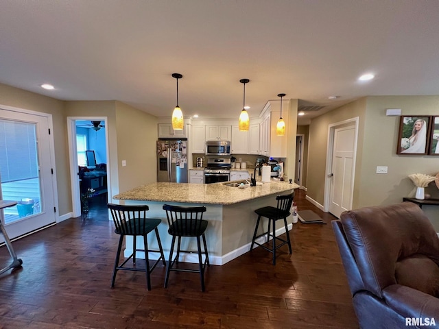 409 W Main St, Williamsville, IL 62693 - kitchen featuring appliances with stainless steel finishes, a peninsula, recessed lighting, white cabinetry, and a kitchen breakfast bar