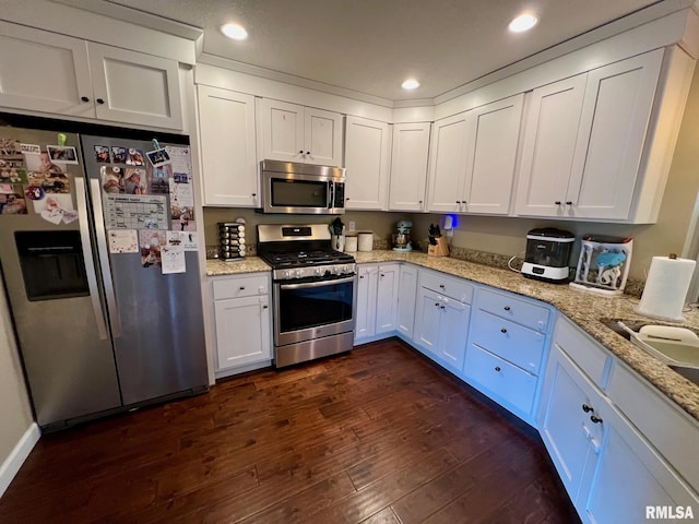 409 W Main St, Williamsville, IL 62693 - kitchen featuring appliances with stainless steel finishes, dark wood-style flooring, white cabinetry, light stone counters, and recessed lighting