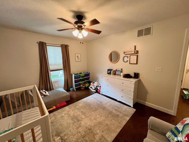 409 W Main St, Williamsville, IL 62693 - bedroom with dark wood-type flooring, a textured ceiling, and a ceiling fan