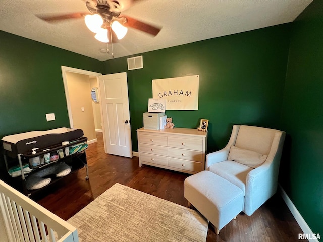 409 W Main St, Williamsville, IL 62693 - bedroom featuring dark wood-style flooring, a textured ceiling, and ceiling fan