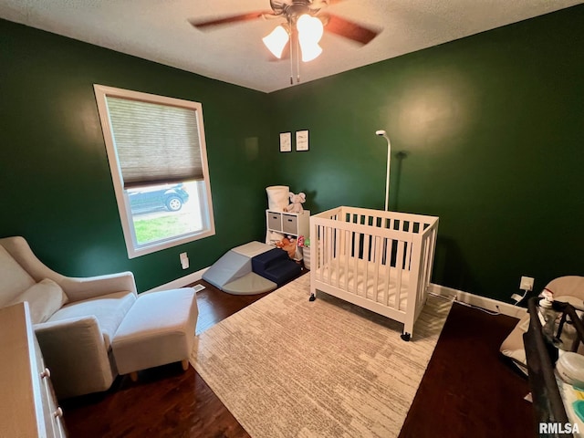 409 W Main St, Williamsville, IL 62693 - bedroom featuring wood finished floors, ceiling fan, and a nursery area