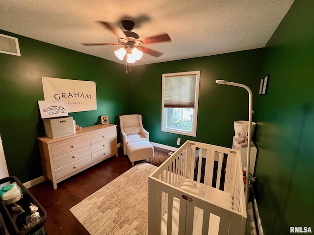 409 W Main St, Williamsville, IL 62693 - bedroom with a nursery area, a textured ceiling, wood finished floors, and a ceiling fan