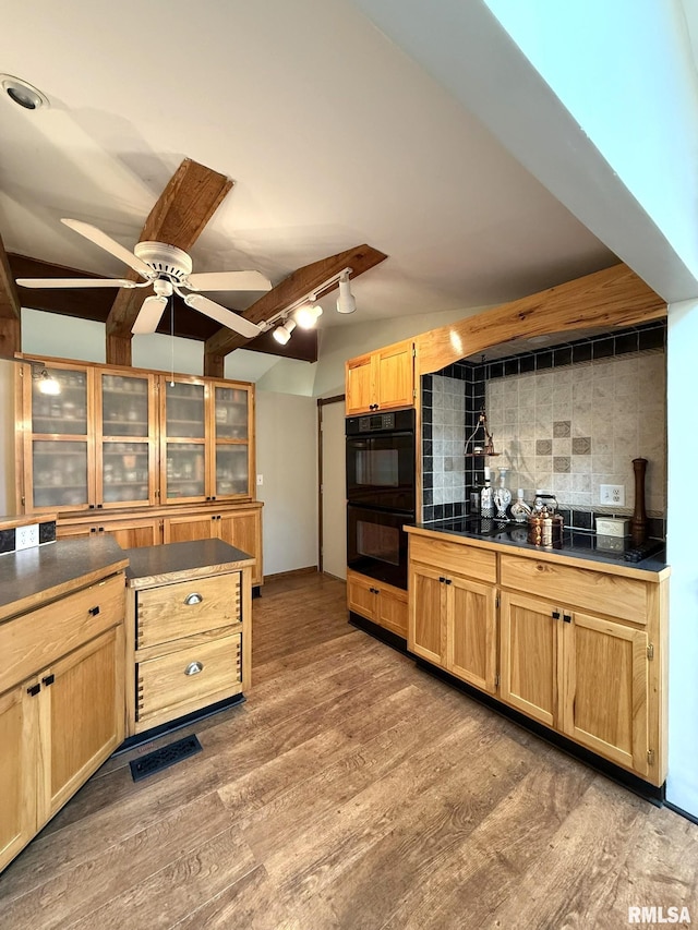 131 E Willard St, Wataga, IL 61488 - kitchen featuring dark countertops, decorative backsplash, light brown cabinetry, light wood-style floors, and beamed ceiling