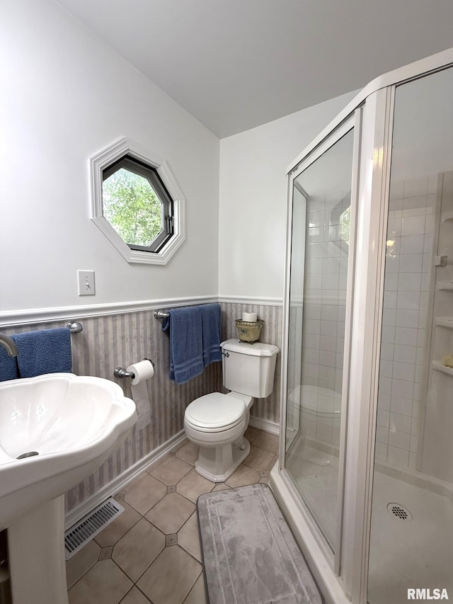 131 E Willard St, Wataga, IL 61488 - bathroom featuring a stall shower, a wainscoted wall, toilet, and tile patterned flooring