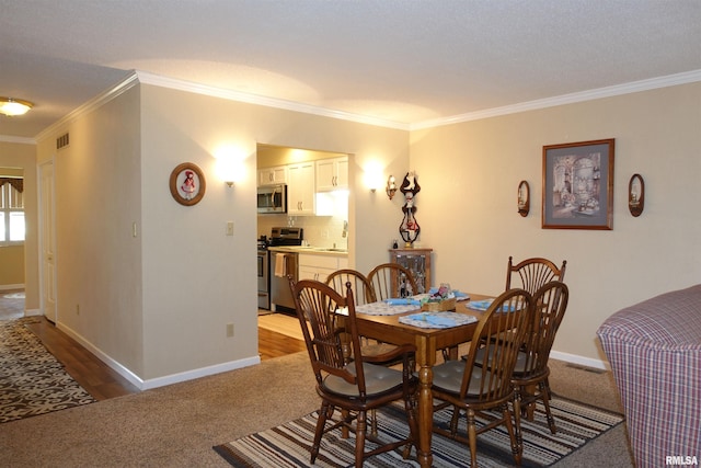 255 S Soangetaha Rd, Galesburg, IL 61401 - dining room featuring dark colored carpet, ornamental molding, and baseboards