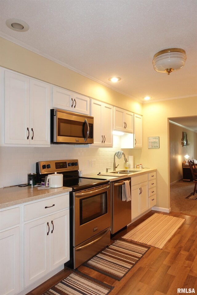 255 S Soangetaha Rd, Galesburg, IL 61401 - kitchen featuring stainless steel appliances, ornamental molding, white cabinetry, decorative backsplash, and recessed lighting