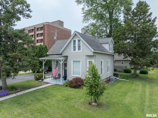 306 N Jefferson St, Abingdon, IL 61410 - view of front of house with roof with shingles, a front yard, and a chimney