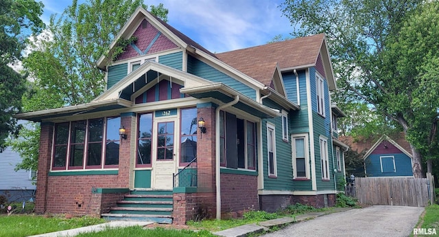 1262 N Broad St, Galesburg, IL 61401 - victorian-style house featuring entry steps, a sunroom, and brick siding