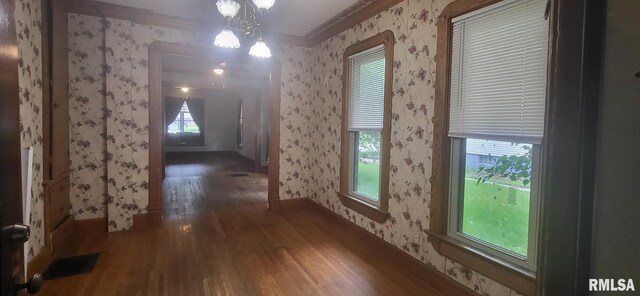 1262 N Broad St, Galesburg, IL 61401 - unfurnished dining area with wallpapered walls, wood finished floors, a chandelier, ornamental molding, and baseboards