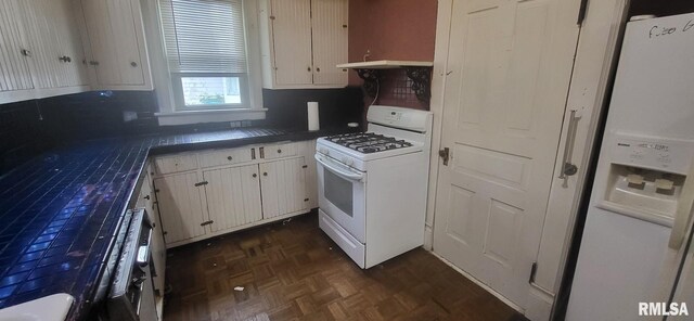 1262 N Broad St, Galesburg, IL 61401 - kitchen featuring white appliances, white cabinetry, under cabinet range hood, and dark countertops