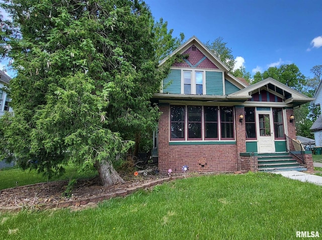 1262 N Broad St, Galesburg, IL 61401 - view of front of property featuring a front lawn, brick siding, entry steps, and a sunroom