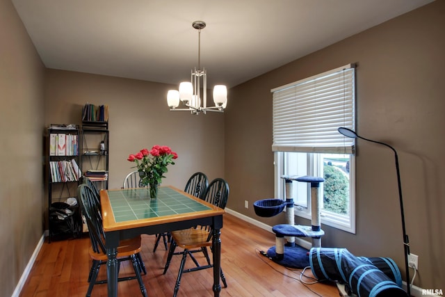507 W Fairway Dr, Quincy, IL 62305 - dining area with baseboards, light wood-style flooring, and a chandelier