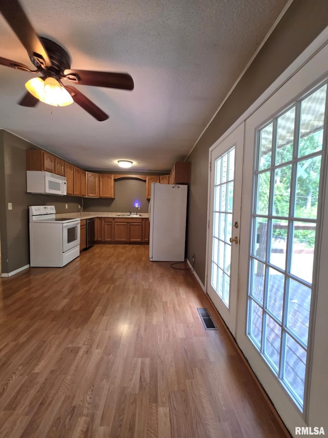 1246 Curtis Creek Rd, Quincy, IL 62301 - kitchen with white appliances, healthy amount of natural light, wood finished floors, a textured ceiling, and a ceiling fan