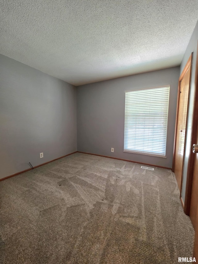 1246 Curtis Creek Rd, Quincy, IL 62301 - spare room featuring carpet flooring, a textured ceiling, and baseboards
