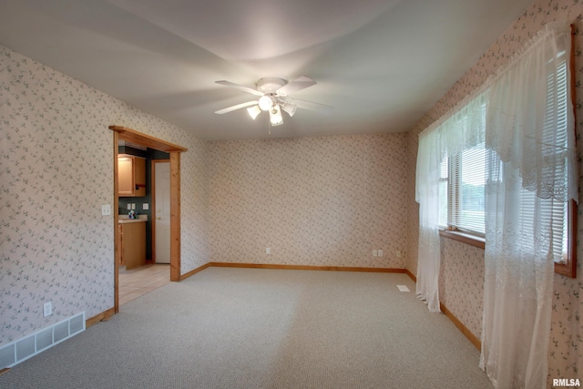 2044 N 1200th Ave, Liberty, IL 62347 - empty room featuring a ceiling fan, wallpapered walls, and light colored carpet