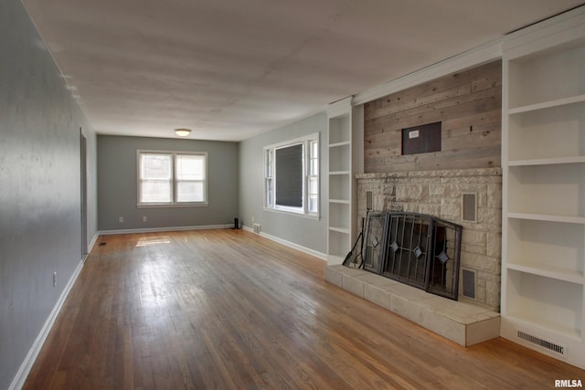 2317 Harrison St, Quincy, IL 62301 - unfurnished living room featuring baseboards, wood finished floors, a fireplace, and built in features