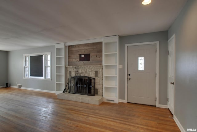 2317 Harrison St, Quincy, IL 62301 - unfurnished living room featuring baseboards, wood finished floors, a fireplace, and built in shelves