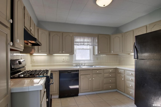 2317 Harrison St, Quincy, IL 62301 - kitchen featuring black appliances, tile countertops, a sink, under cabinet range hood, and backsplash