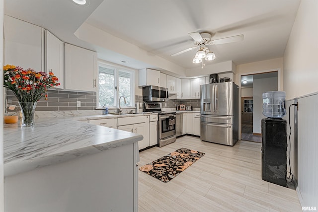 1354 Airport Rd, Lincoln, IL 62656 - kitchen featuring stainless steel appliances, a sink, a ceiling fan, decorative backsplash, and white cabinets