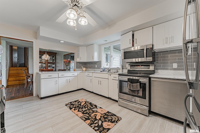 1354 Airport Rd, Lincoln, IL 62656 - kitchen featuring stainless steel appliances, decorative backsplash, a ceiling fan, white cabinets, and a sink