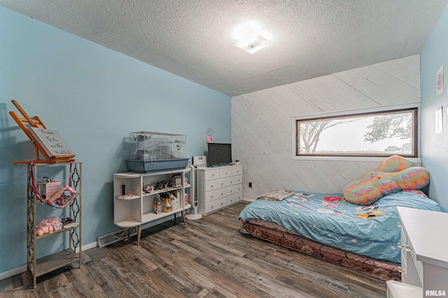 1354 Airport Rd, Lincoln, IL 62656 - bedroom featuring wooden walls, wood finished floors, a textured ceiling, and an accent wall