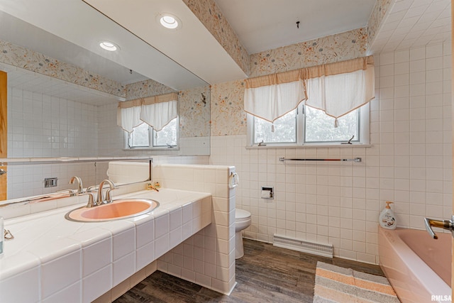 1354 Airport Rd, Lincoln, IL 62656 - bathroom featuring toilet, tile walls, a garden tub, wood finished floors, and wallpapered walls