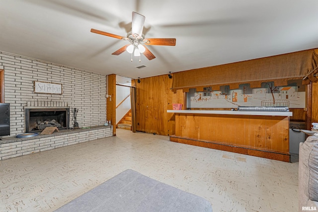1354 Airport Rd, Lincoln, IL 62656 - kitchen featuring tile patterned floors, a ceiling fan, wood walls, a brick fireplace, and open floor plan
