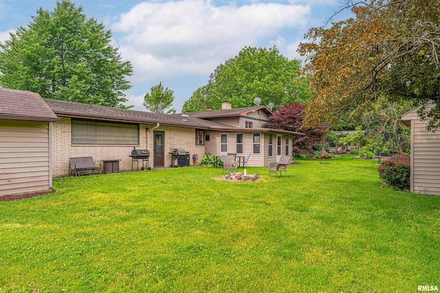 1354 Airport Rd, Lincoln, IL 62656 - rear view of house featuring a yard, brick siding, and a chimney