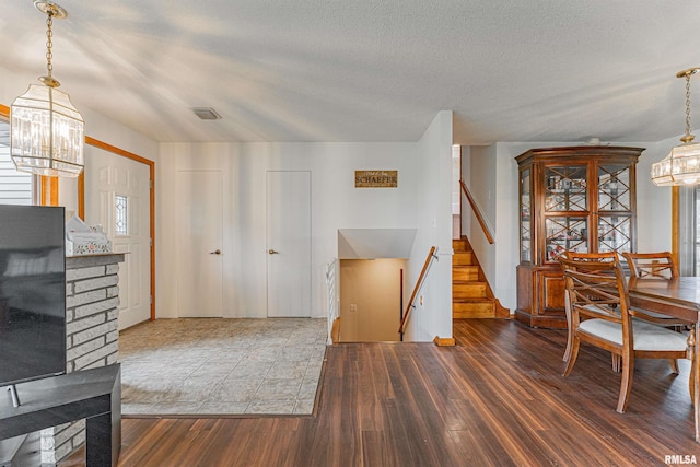 1354 Airport Rd, Lincoln, IL 62656 - dining area featuring a chandelier, wood finished floors, stairway, a textured ceiling, and healthy amount of natural light