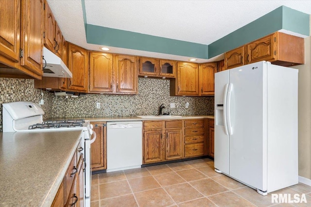 69 Axline Rd, Chatham, IL 62629 - kitchen featuring white appliances, under cabinet range hood, brown cabinetry, backsplash, and light tile patterned floors