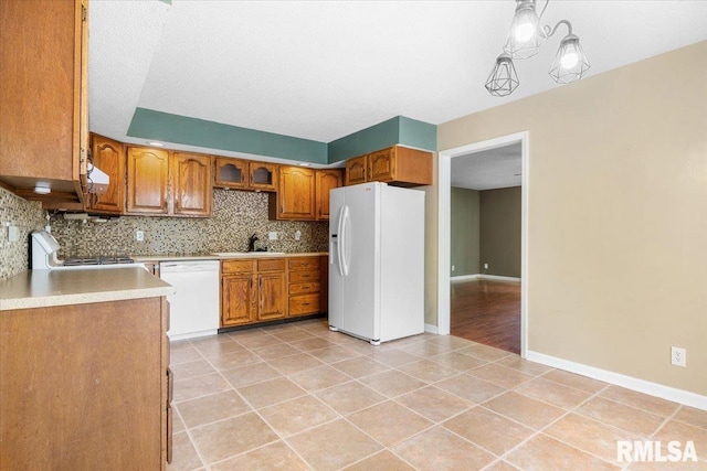 69 Axline Rd, Chatham, IL 62629 - kitchen featuring white appliances, brown cabinetry, tasteful backsplash, light tile patterned flooring, and light countertops